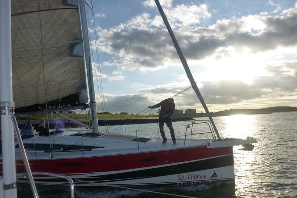 un uomo in piedi su una barca a vela in acqua