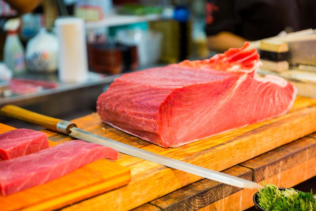 用刀在砧板上切两片肉