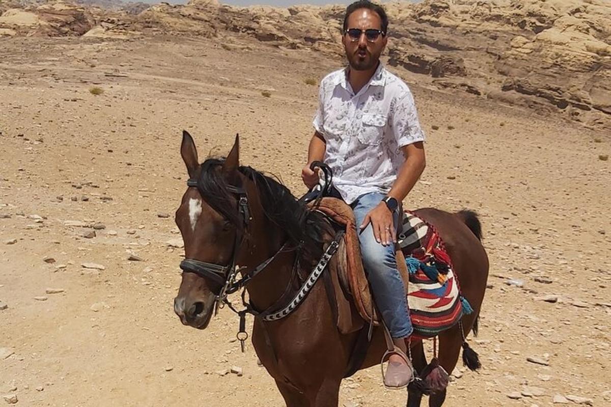 a man riding a horse in the desert