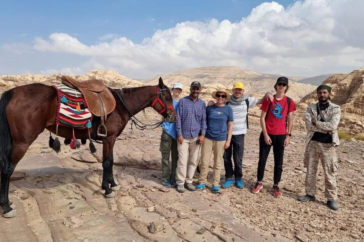 a group of people and a horse in the desert