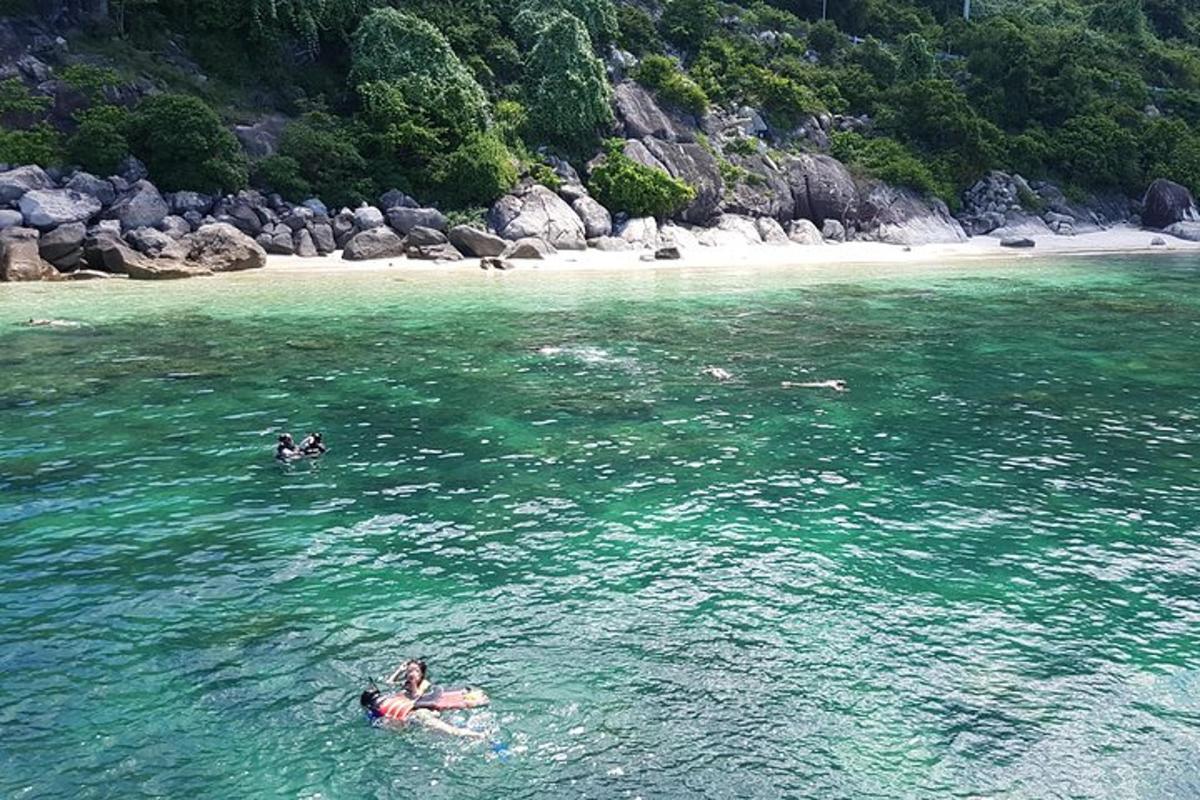 two people swimming in the water near a beach
