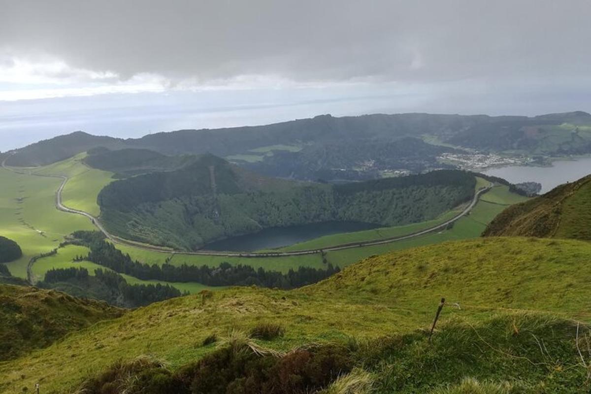 a view of a green valley with a lake on a hill