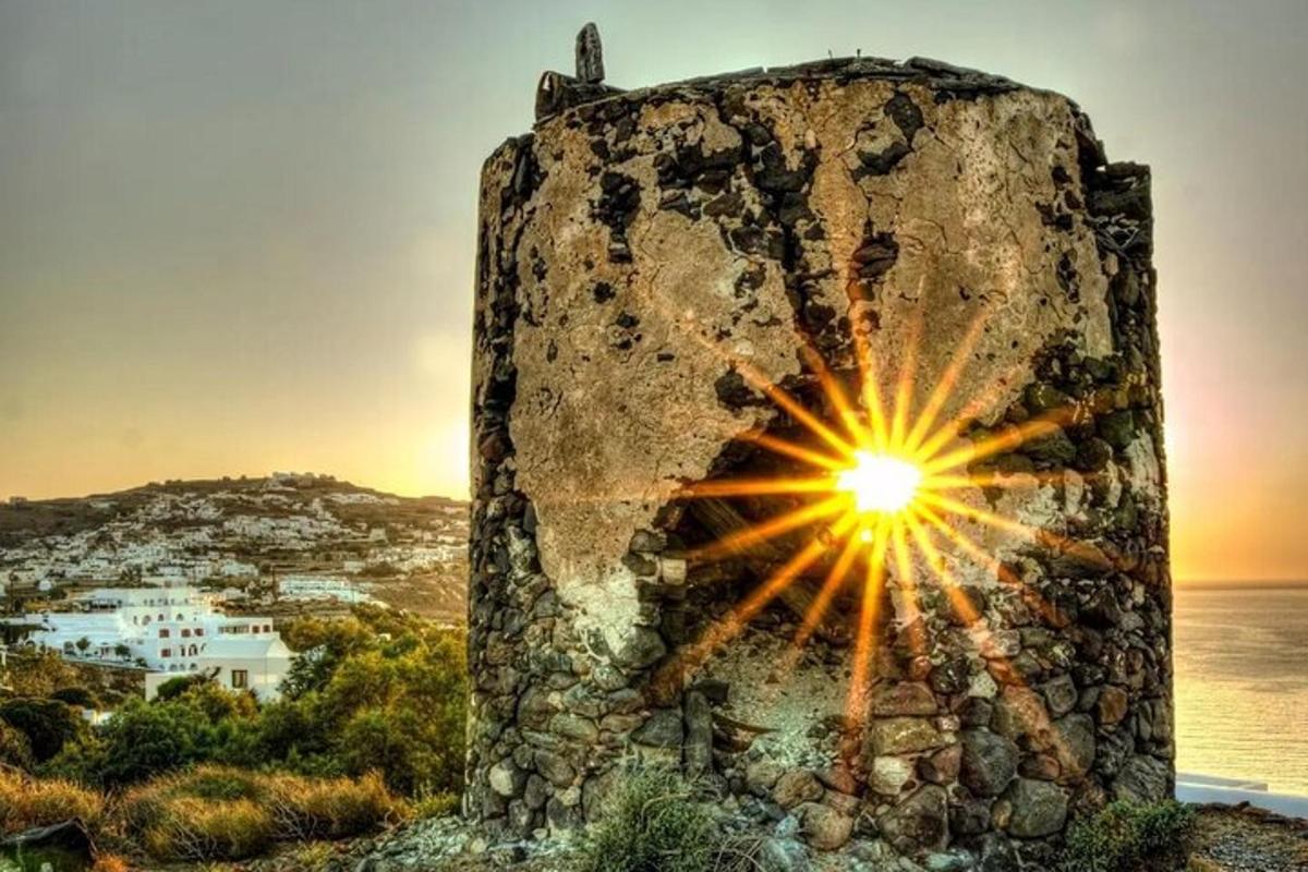 un muro di pietra con un sole sopra vicino all'oceano