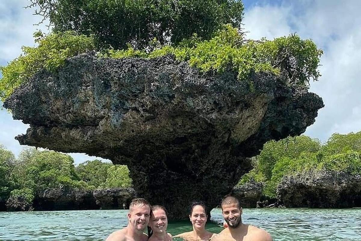 quattro persone in piedi nell'acqua di fronte a un'isola