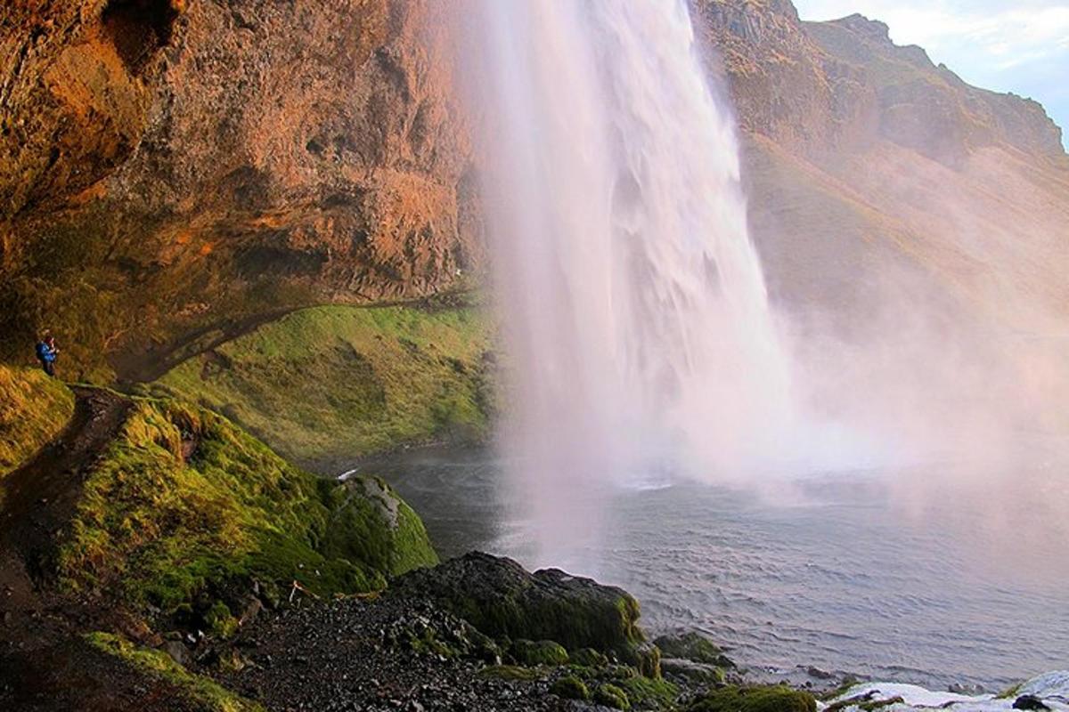 air terjun dengan seseorang berdiri di hadapannya