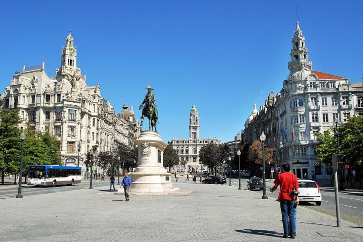 um homem parado em frente a uma estátua em uma cidade