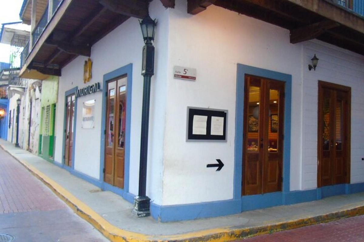 a white building with wooden doors on a street
