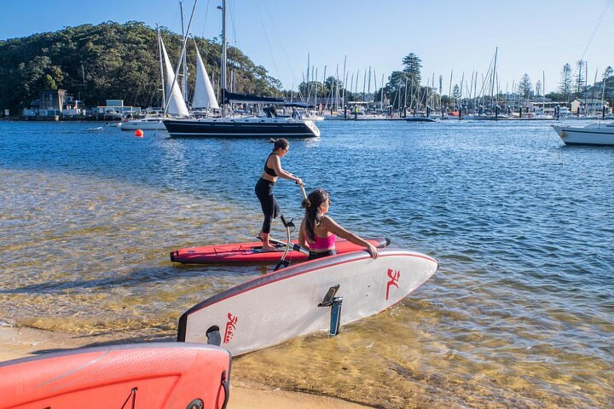 zwei Mädchen stehen auf einem Surfbrett im Wasser