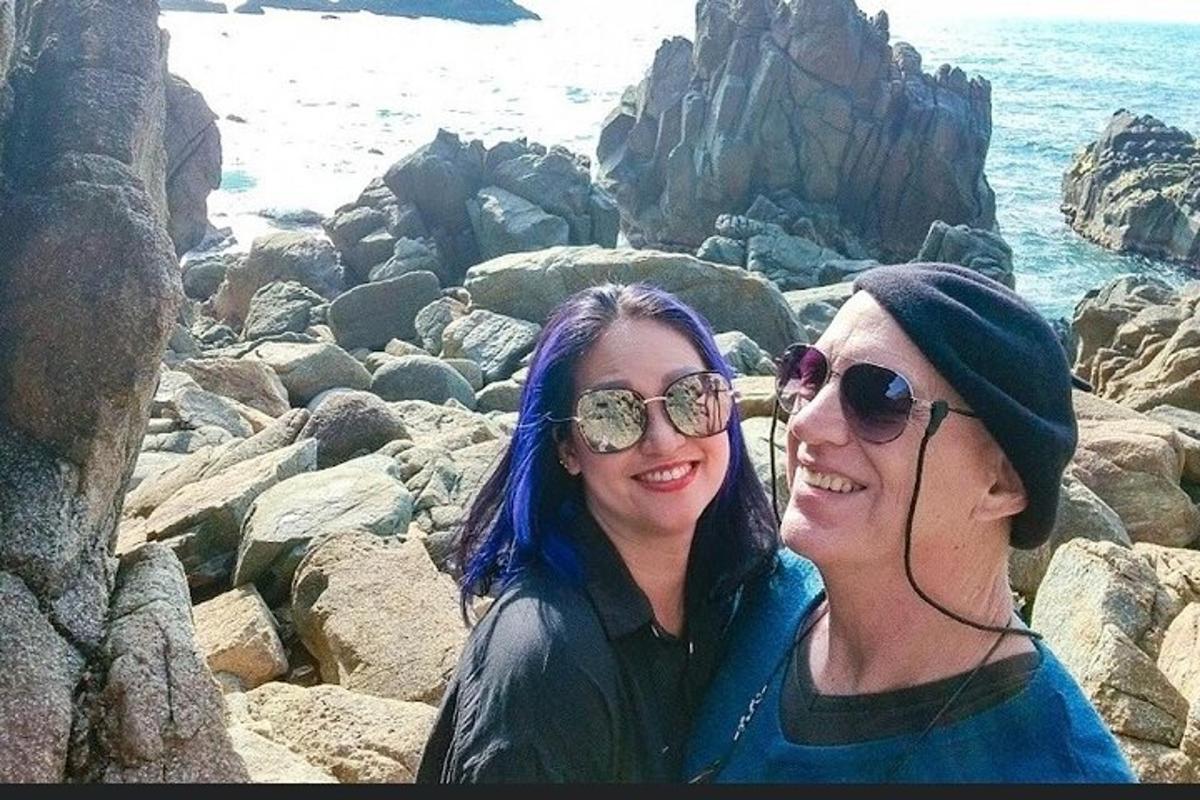 two women standing on the rocks near the ocean