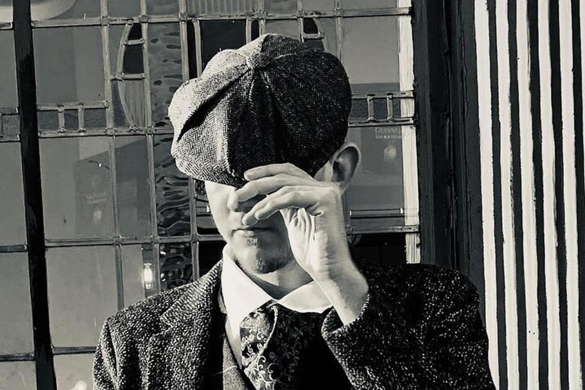 um homem usando um chapéu está falando ao celular