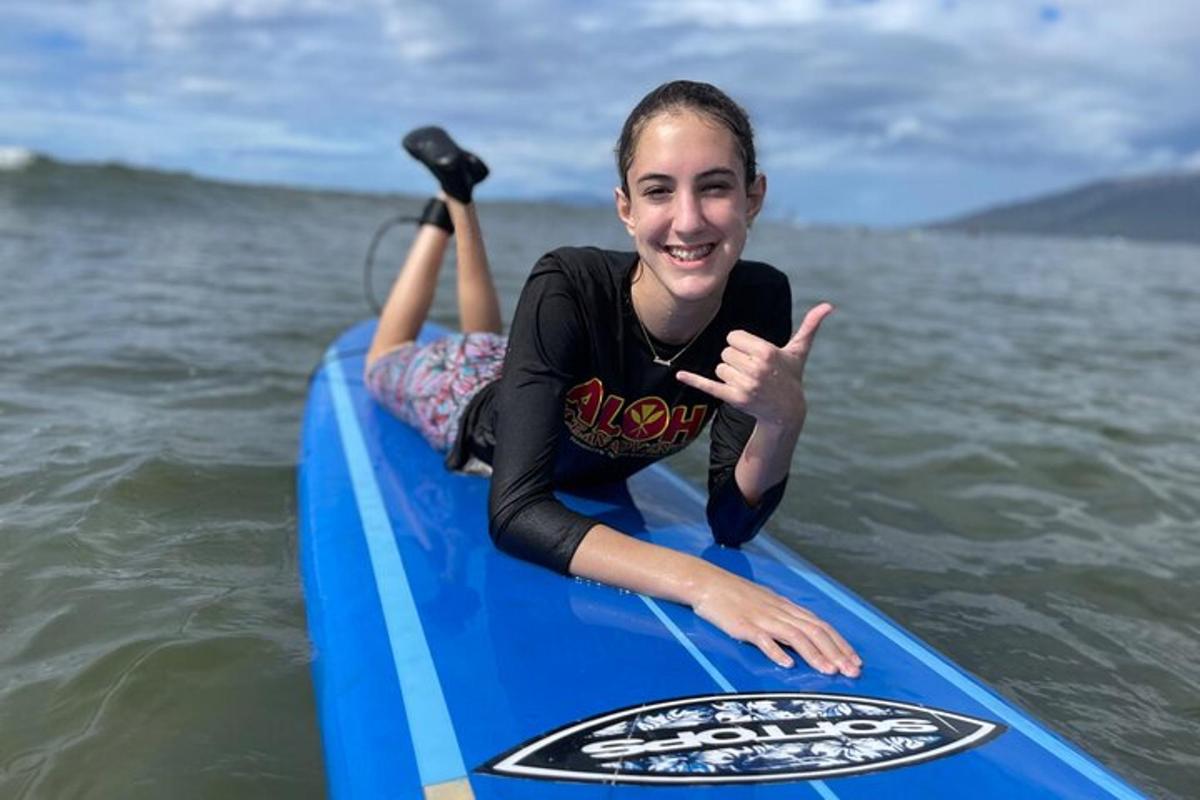 o tânără fată stă pe o placă de surf în apă