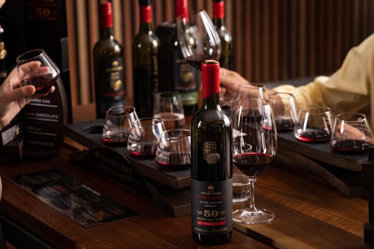una bottiglia di vino appoggiata su un tavolo con bicchieri da vino