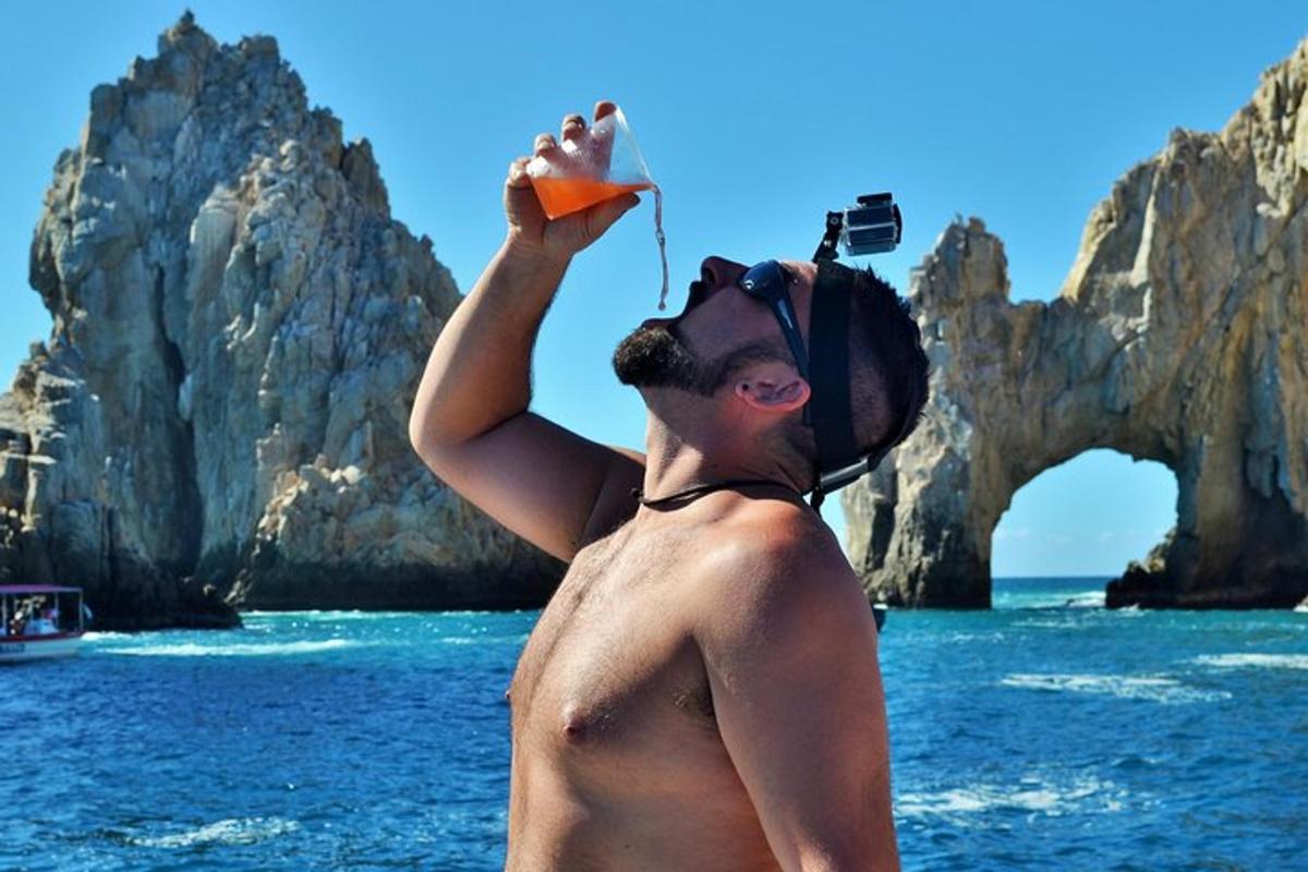 moški, ki stoji v vodi z oranžnim predmetom v roki