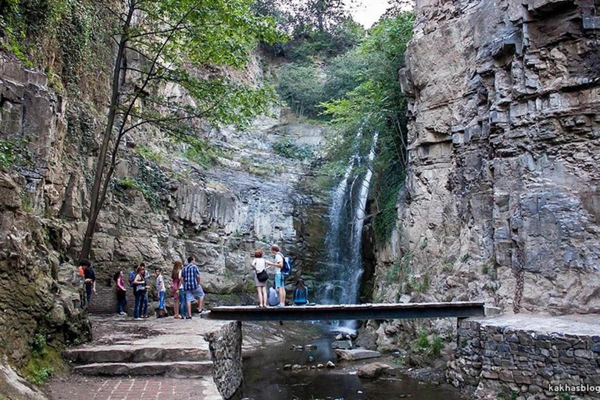 sekumpulan orang berdiri di hadapan air terjun