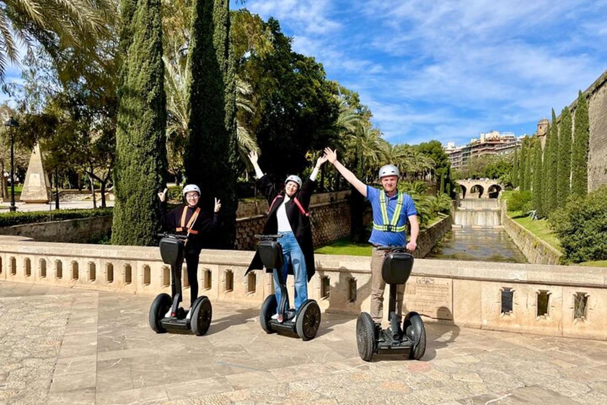 un bărbat și două femei care călătoresc cu Segway-uri într-un parc