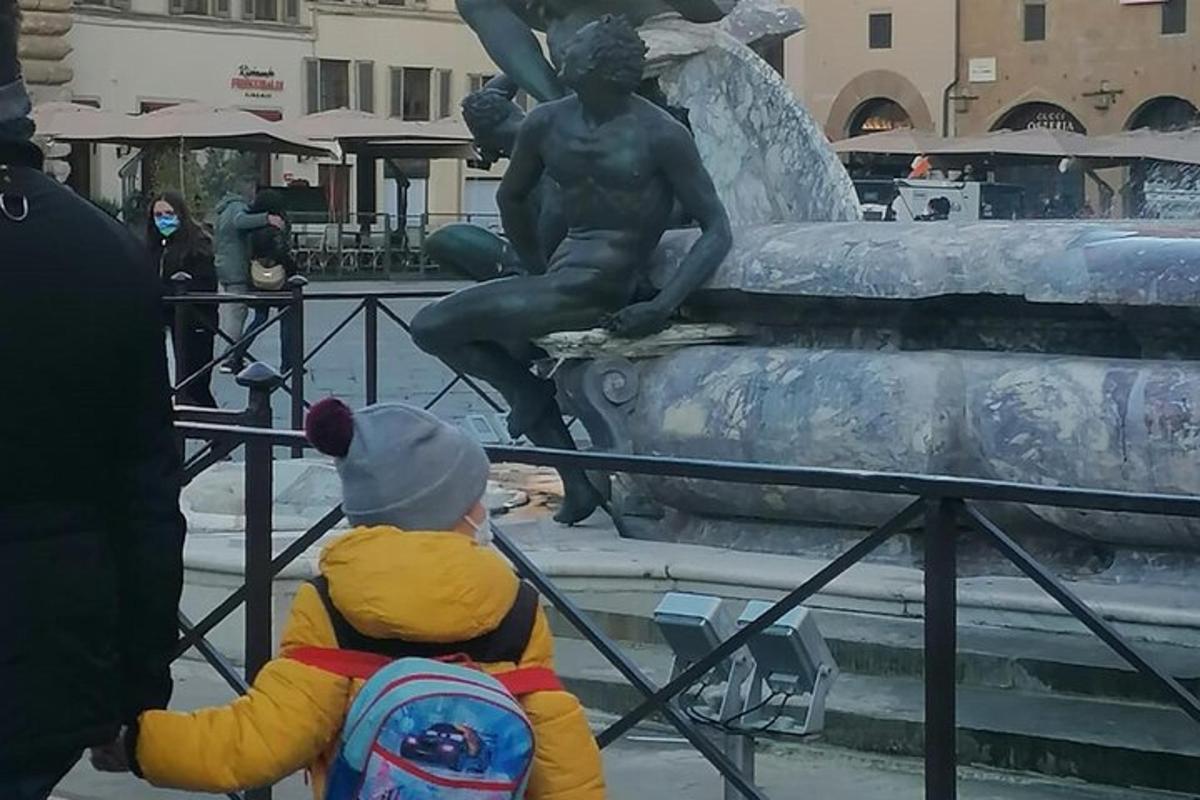 ένα μικρό παιδί που στέκεται μπροστά σε ένα άγαλμα