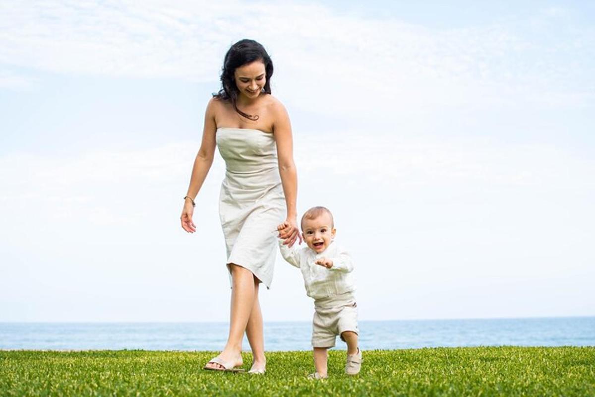 a woman and a child walking on the beach