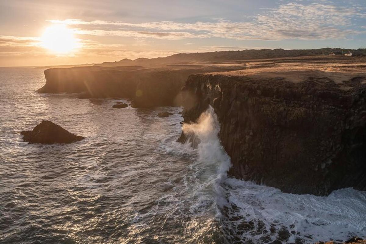 an aerial view of the ocean and a rocky cliff