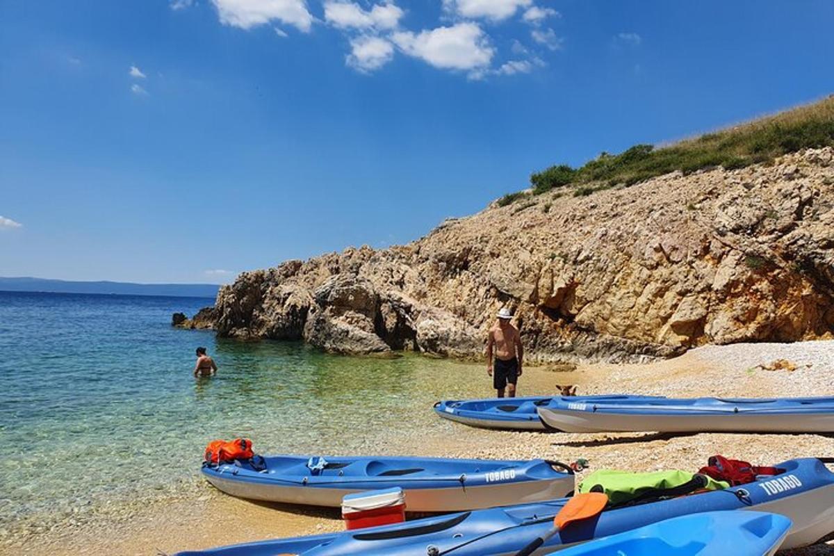 a group of boats on a beach with people in the water