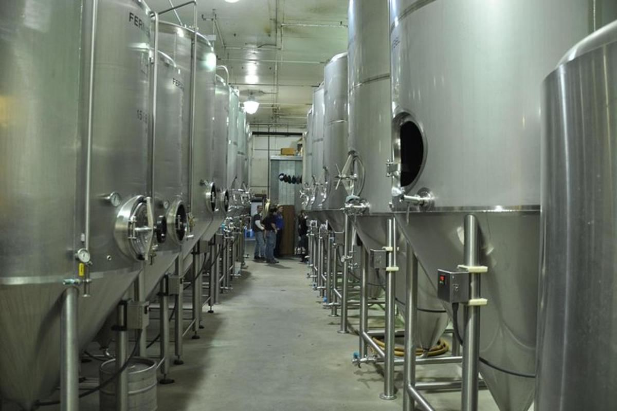a row of stainless steel tanks in a brewery