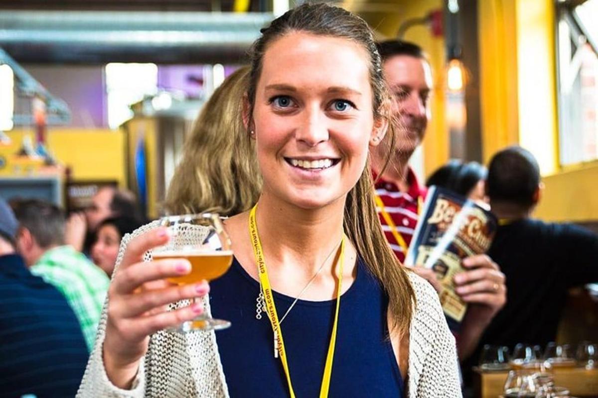 a woman is holding a glass of beer