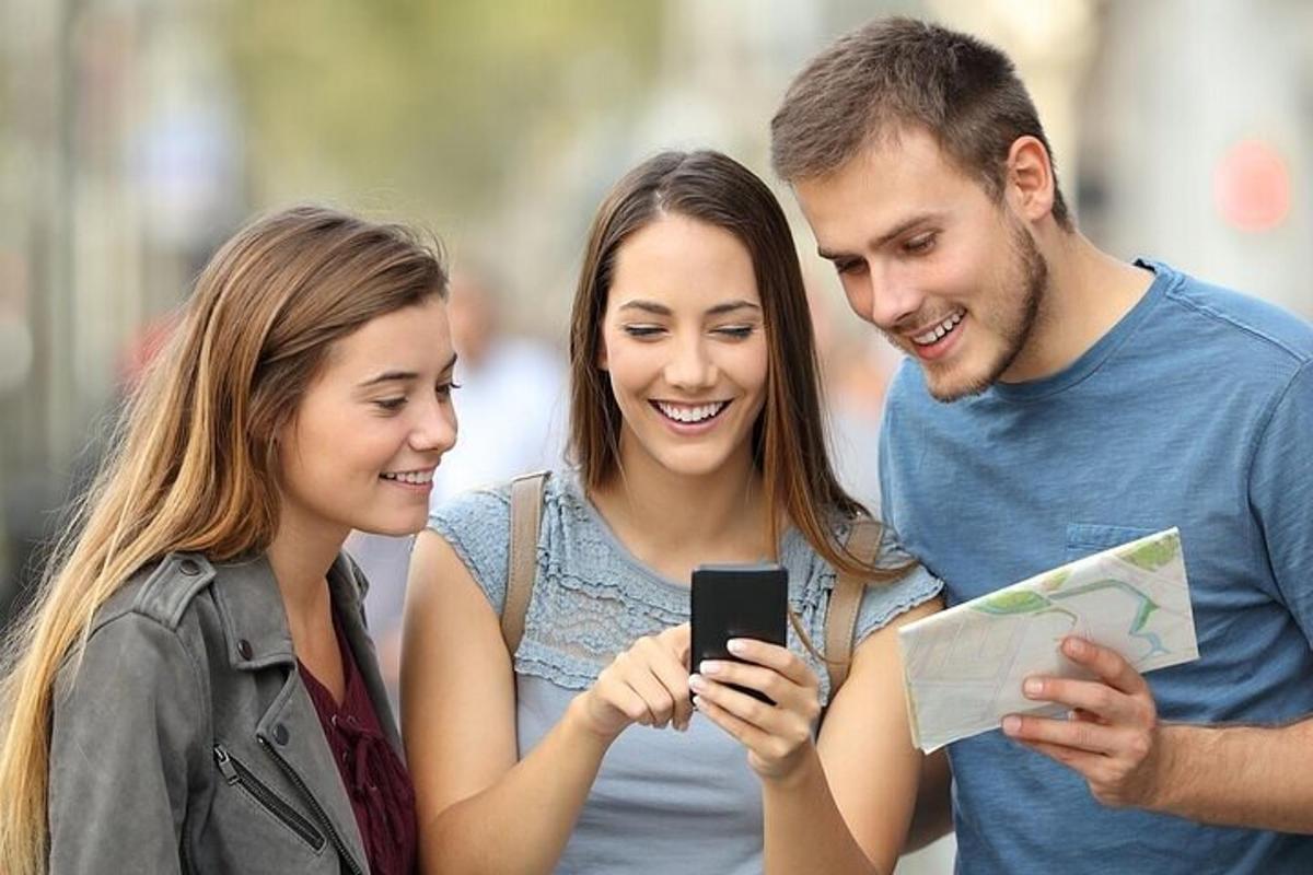 một nhóm ba người đang nhìn vào một chiếc điện thoại di động