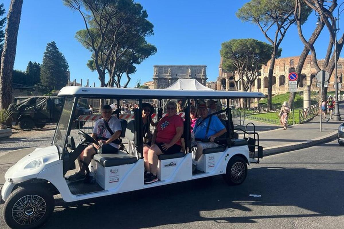 skupina lidí jedoucích v golfovém vozíku