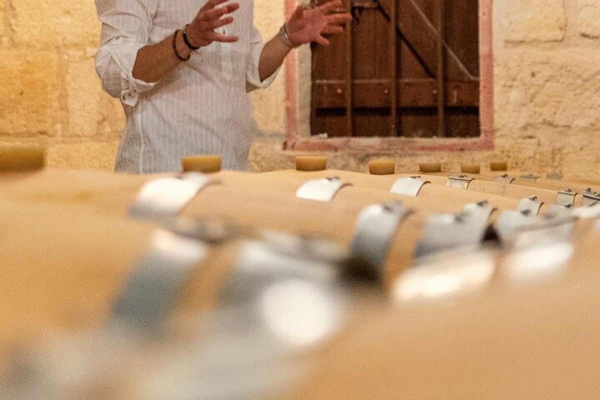 a man is standing in front of a row of wine bottles