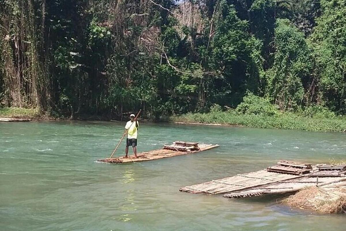 seorang lelaki sedang berdiri di atas rakit di sungai