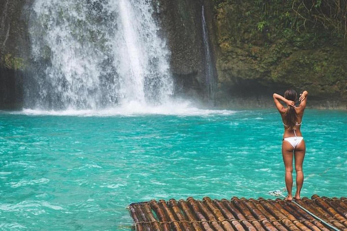 Una mujer parada en el agua cerca de una cascada
