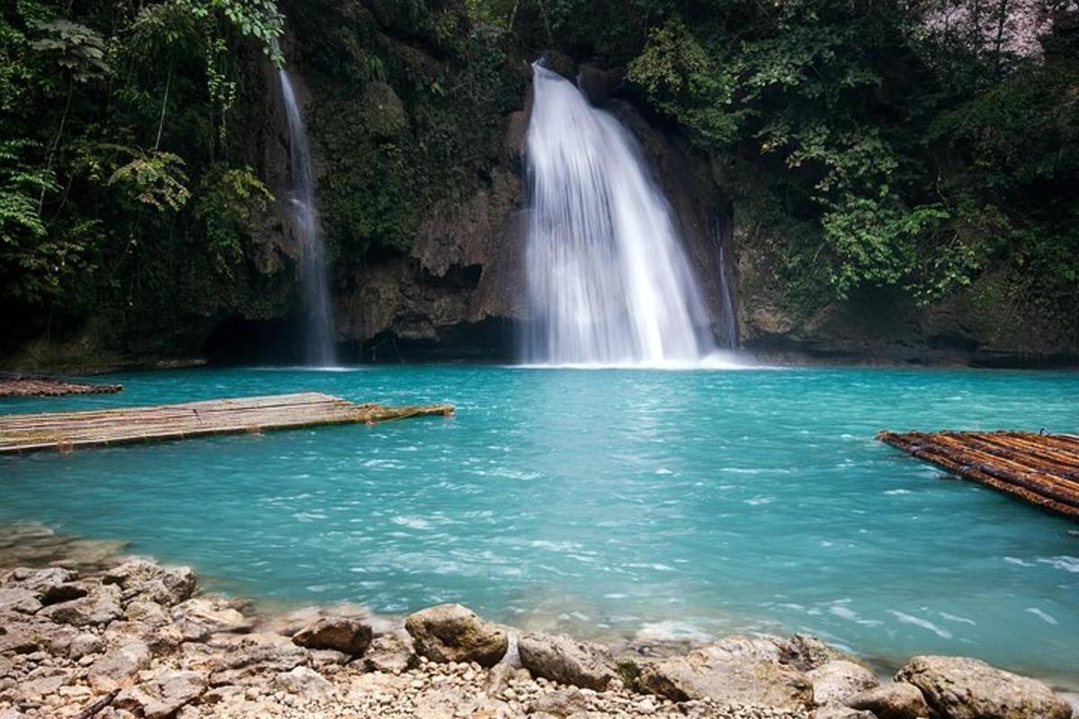 una cascada davant d'un estany d'aigua