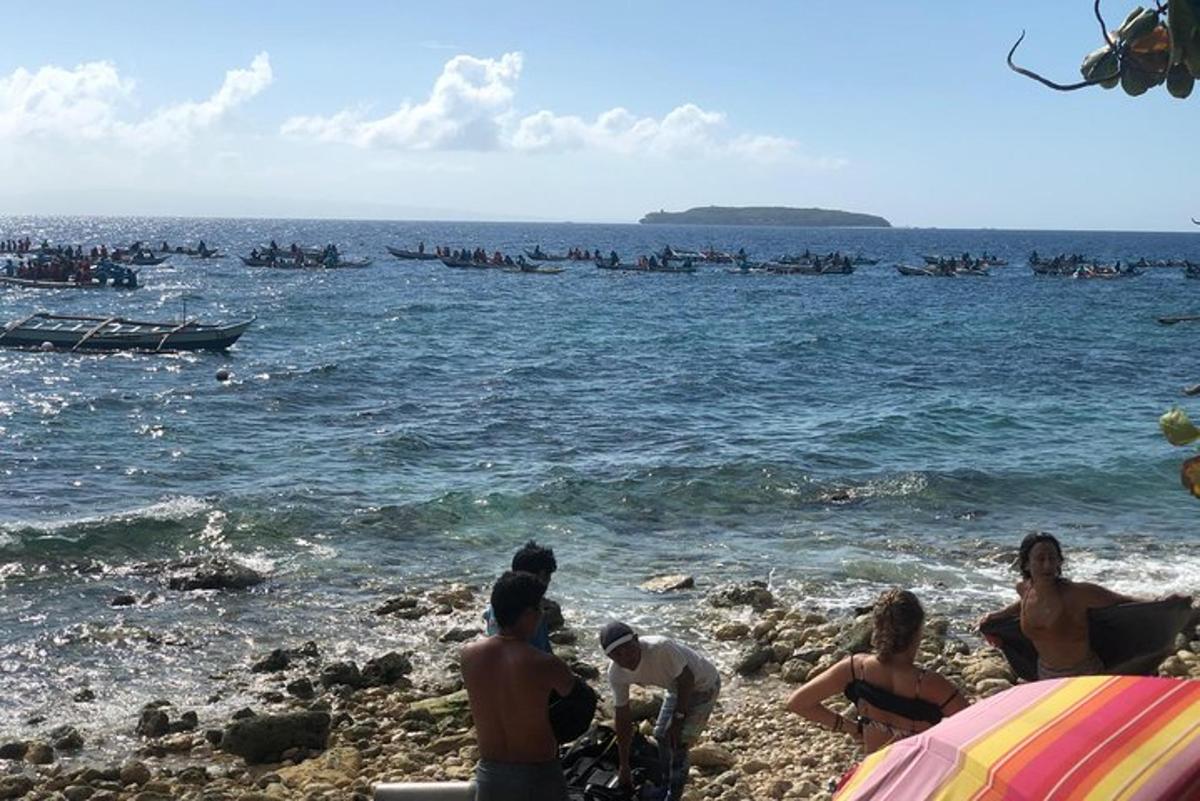 grupp inimesi rannas, paadid vees