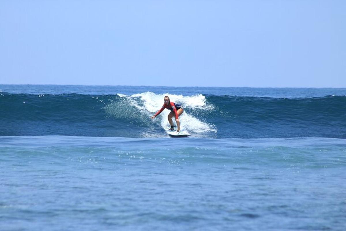 un bărbat călărind un val pe o placă de surf în ocean