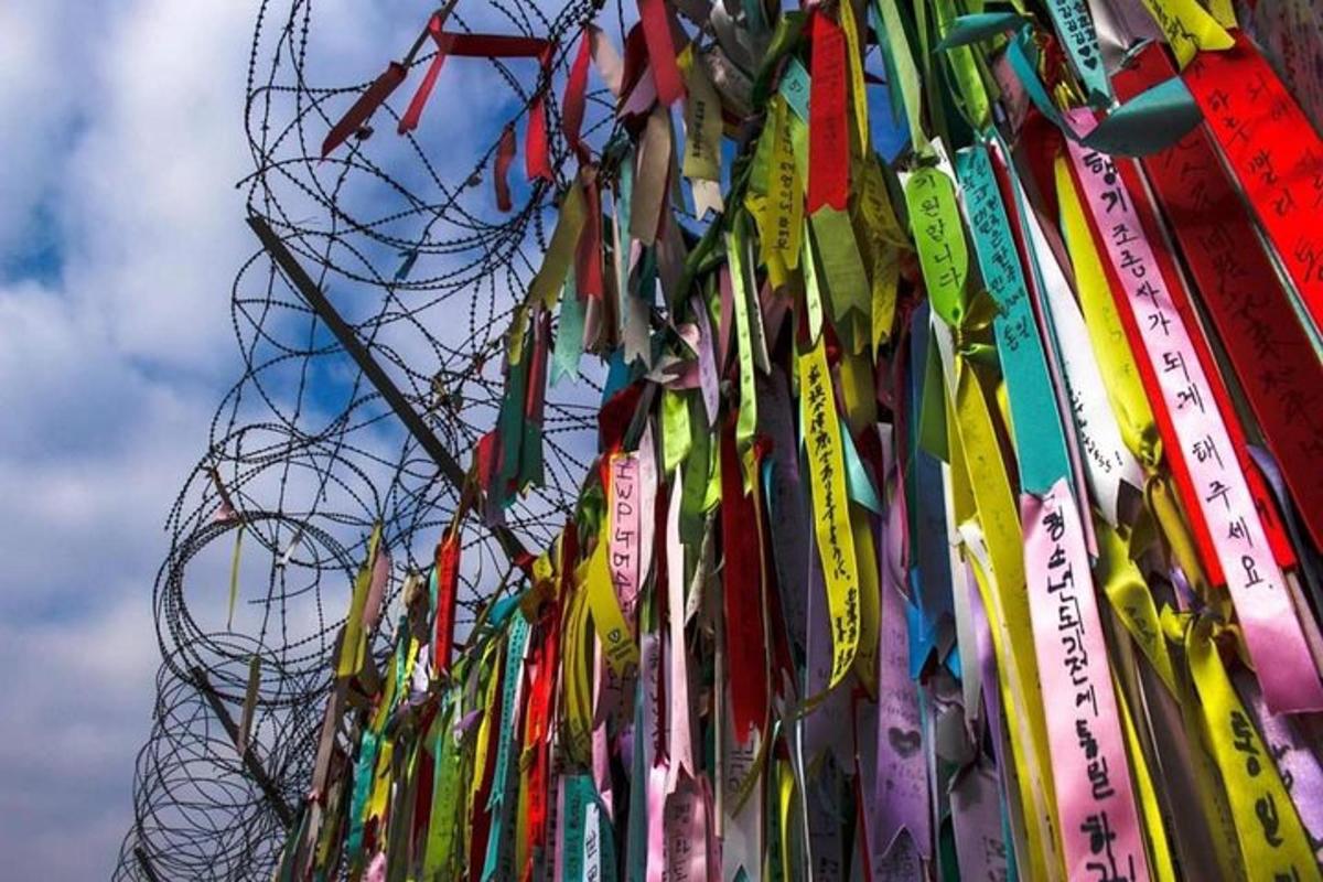 a bunch of ribbons are hanging on a fence