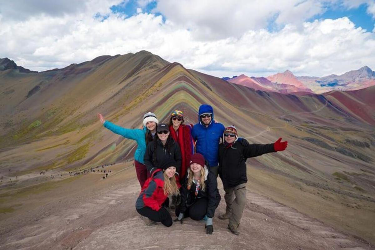 un gruppo di persone in posa davanti a una montagna