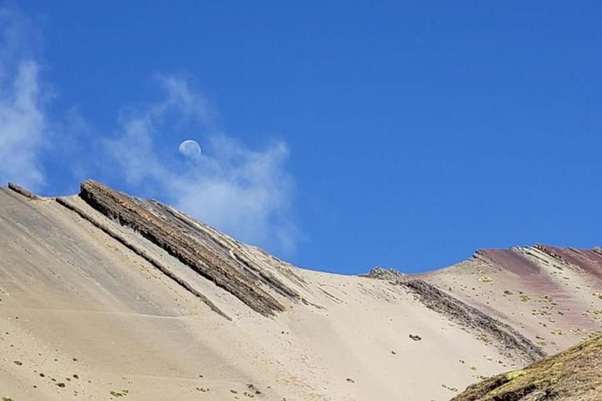 ein Sandhügel mit dem Mond am Himmel