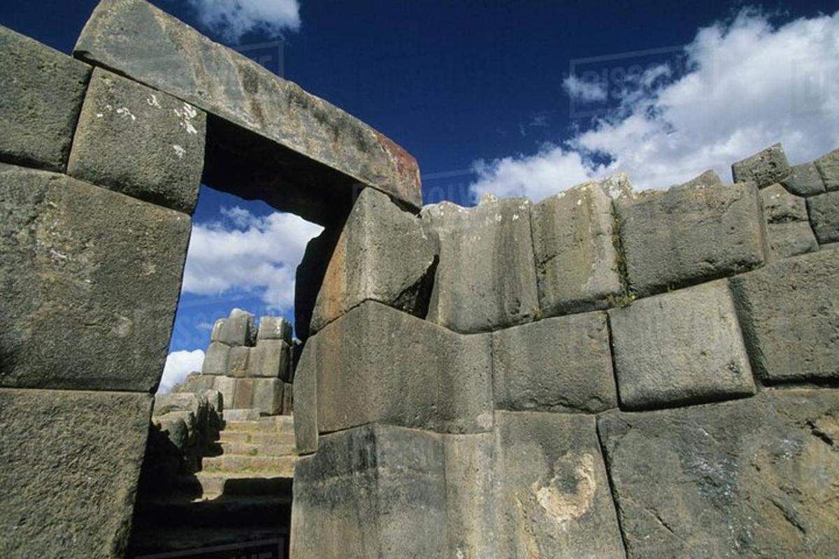 a stone wall with a stairway leading through an arch