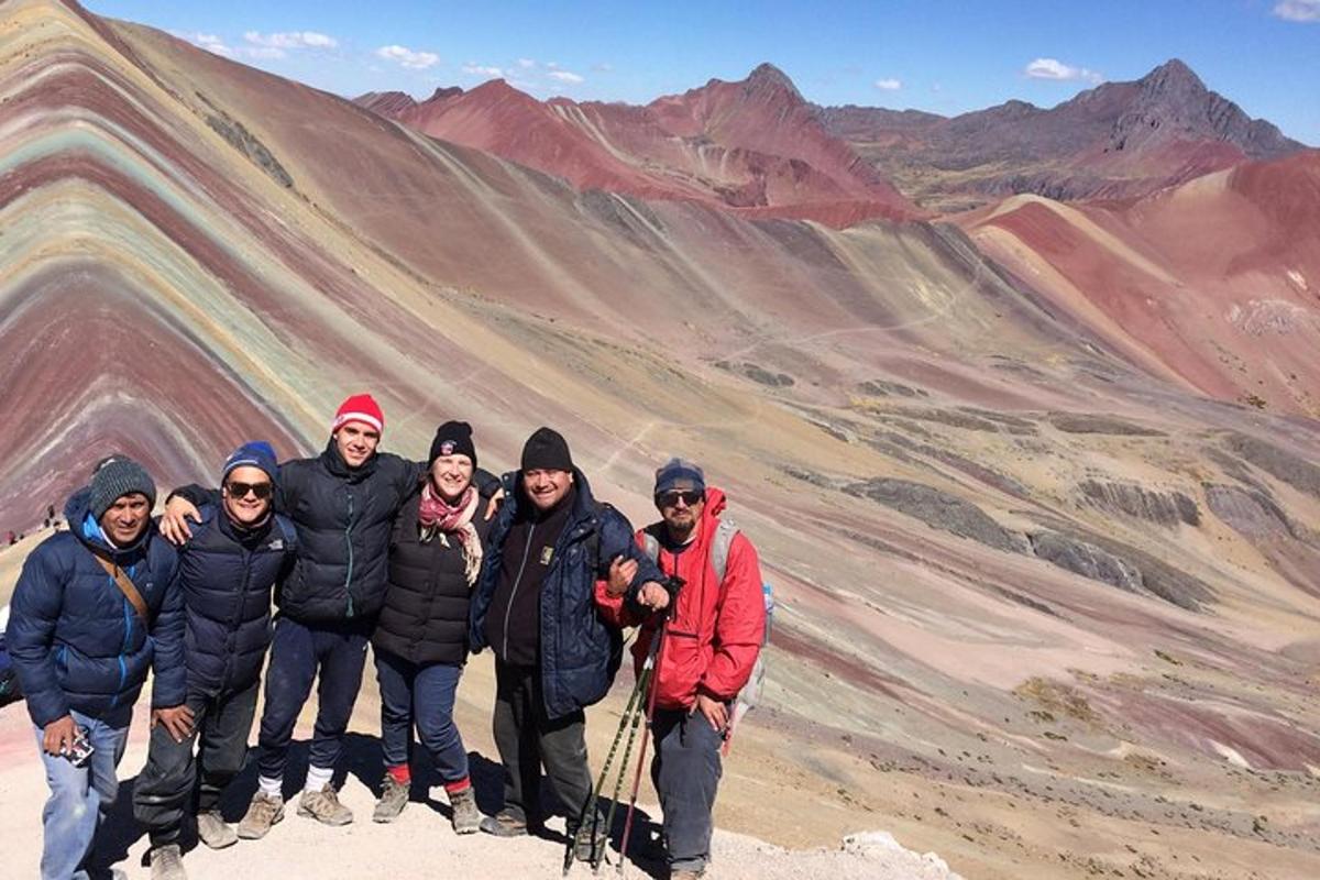 un grup de oameni care stau pe vârful unui munte