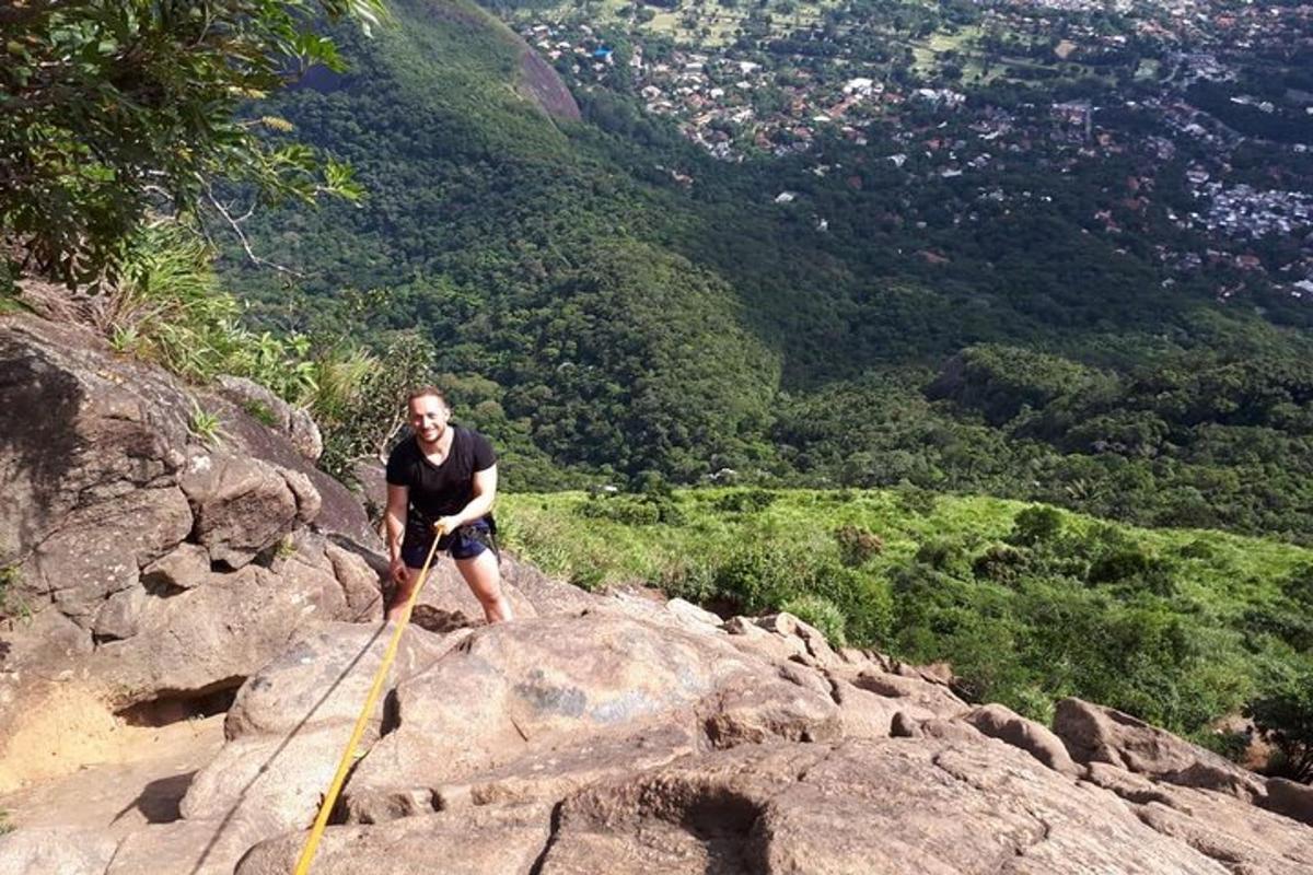 um homem em pé no topo de uma montanha rochosa