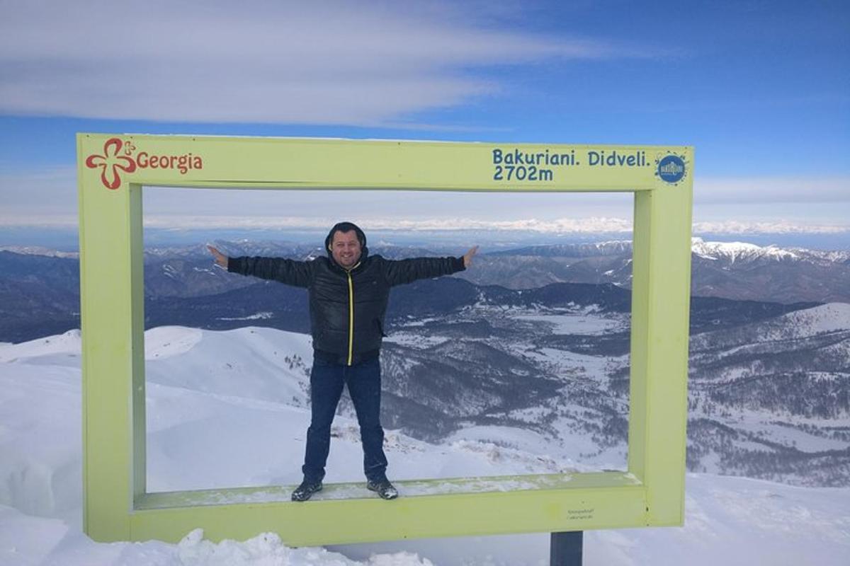 Un hombre parado en lo alto de un cartel en una montaña