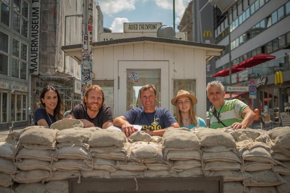 eine Gruppe von Menschen steht hinter einer Steinmauer