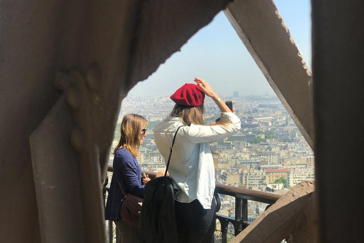 two women standing on top of a tower looking at a city