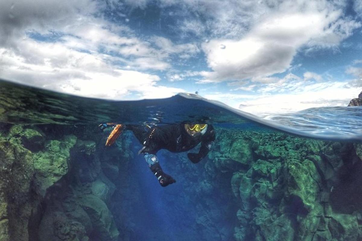 eine Person schwimmt unter einem Surfbrett im Meer
