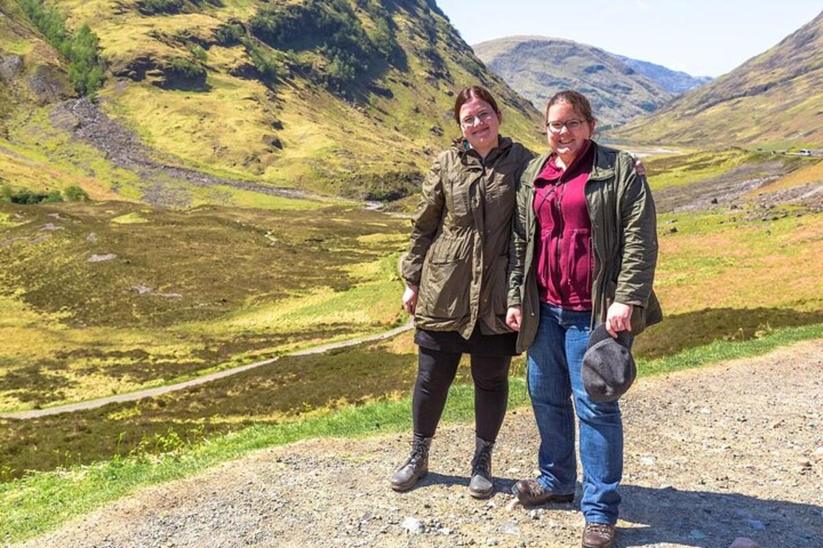 two women standing on a dirt road in a mountain