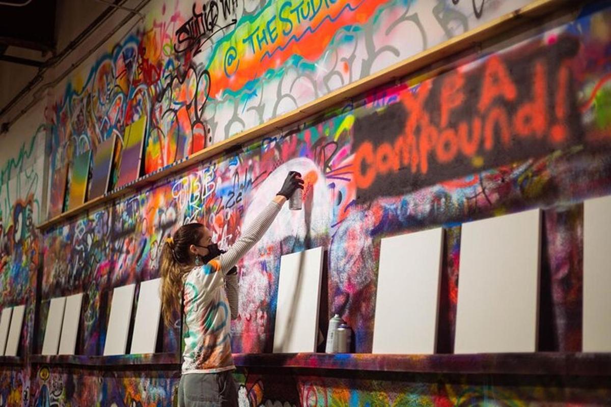osoba malující zeď graffiti