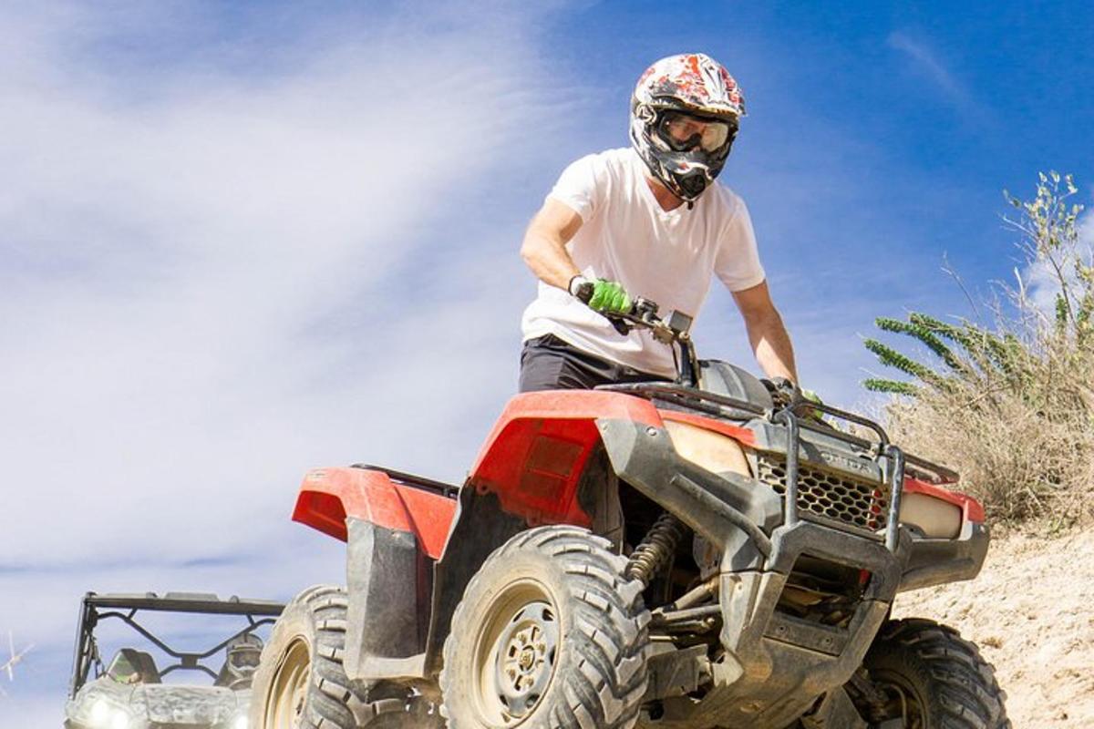 a man riding a quad bike on the beach