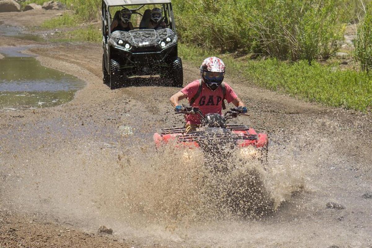 a person riding a four wheeler in the mud