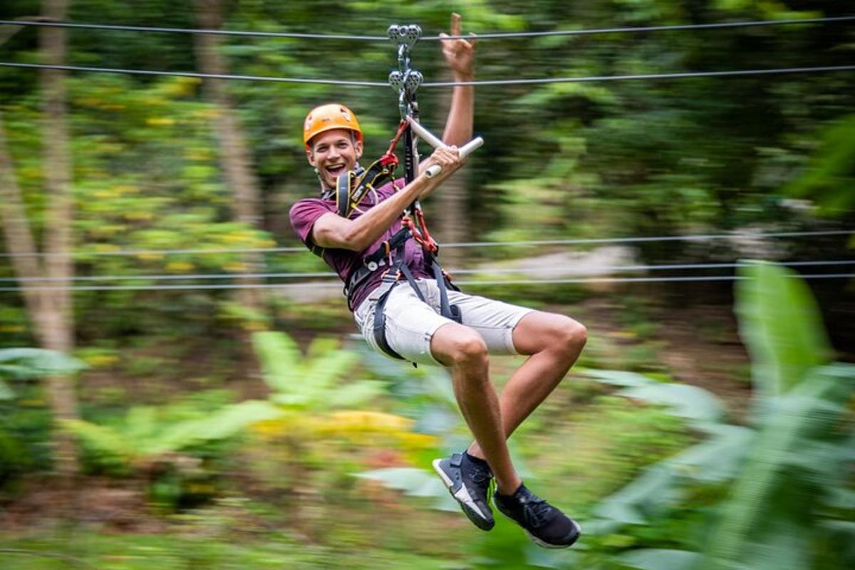 a man on a zip line in the jungle