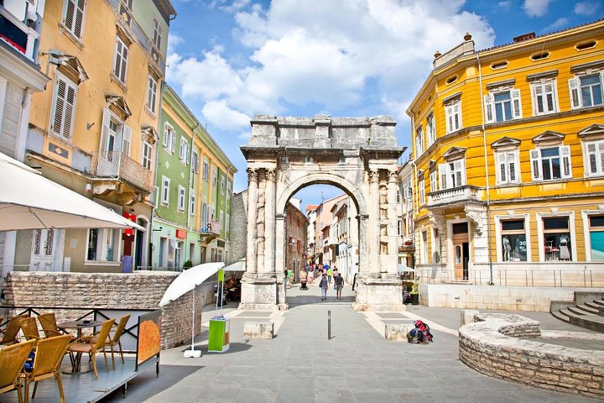 an arch in the middle of a city with buildings