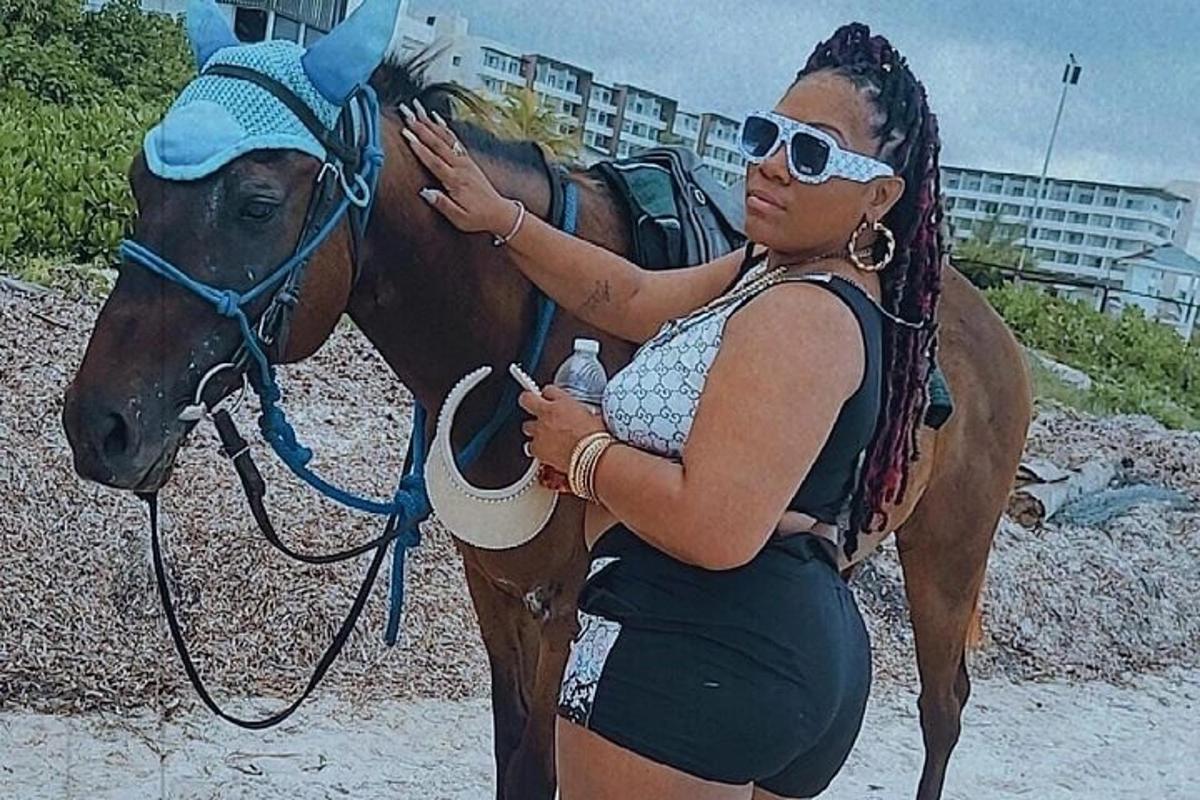 una donna è in piedi accanto a un cavallo